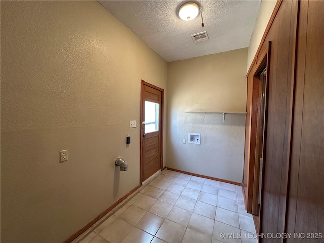 clothes washing area featuring visible vents, baseboards, laundry area, hookup for a washing machine, and a textured ceiling