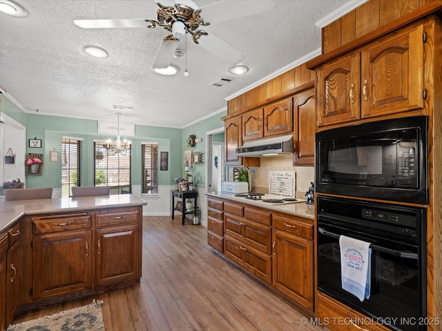 kitchen with ornamental molding, a textured ceiling, under cabinet range hood, and black appliances