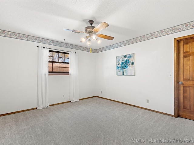 carpeted empty room featuring baseboards and a ceiling fan