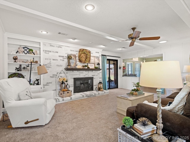 living room with visible vents, a textured ceiling, a large fireplace, carpet, and ceiling fan