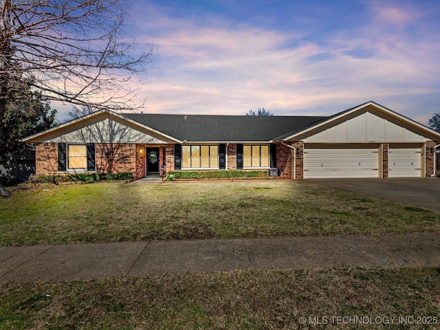 view of front of house with a garage, brick siding, concrete driveway, and a front yard