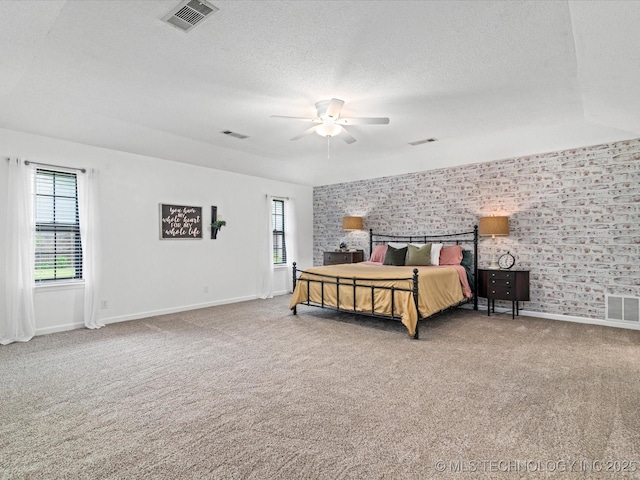 2540 Chapel Hill Rd, Bartlesville, OK 74006 - bedroom featuring carpet, baseboards, multiple windows, a textured ceiling, and brick wall