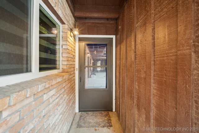 entrance to property featuring brick siding