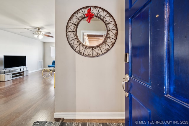 entrance foyer with visible vents, ceiling fan, baseboards, and wood finished floors