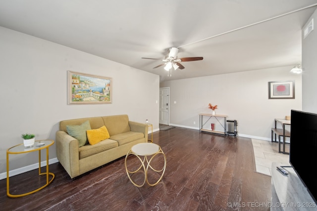 living area with baseboards, ceiling fan, and wood finished floors