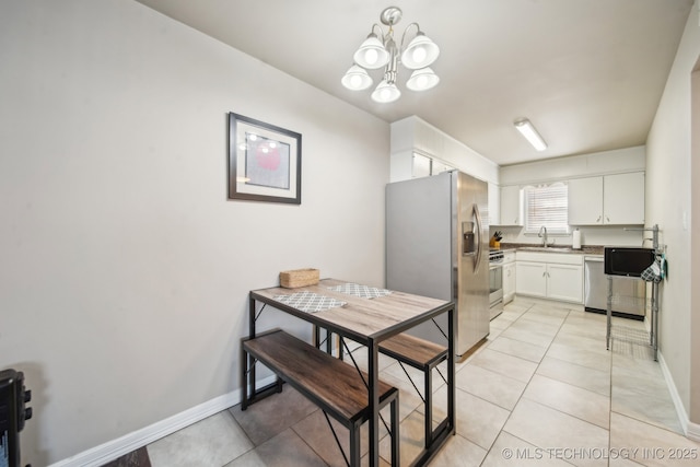 dining space featuring a notable chandelier, light tile patterned floors, and baseboards