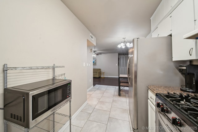 kitchen with visible vents, baseboards, light tile patterned floors, white cabinets, and stainless steel appliances