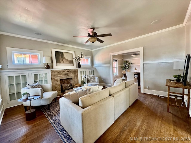 living room with plenty of natural light, ornamental molding, a ceiling fan, and dark wood-style flooring