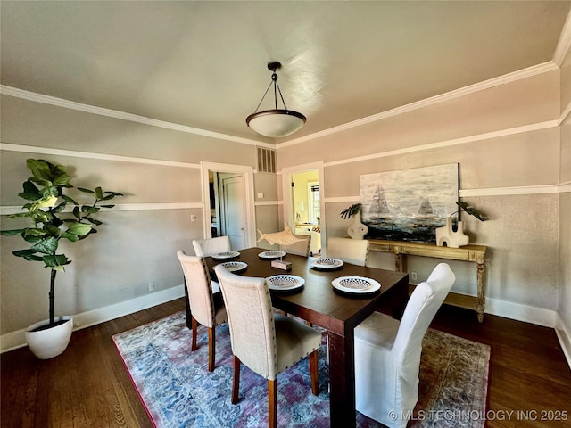 dining space featuring visible vents, ornamental molding, baseboards, and wood finished floors