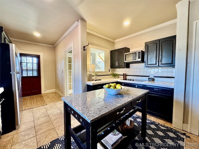 kitchen featuring stainless steel appliances, ornamental molding, decorative backsplash, and light countertops