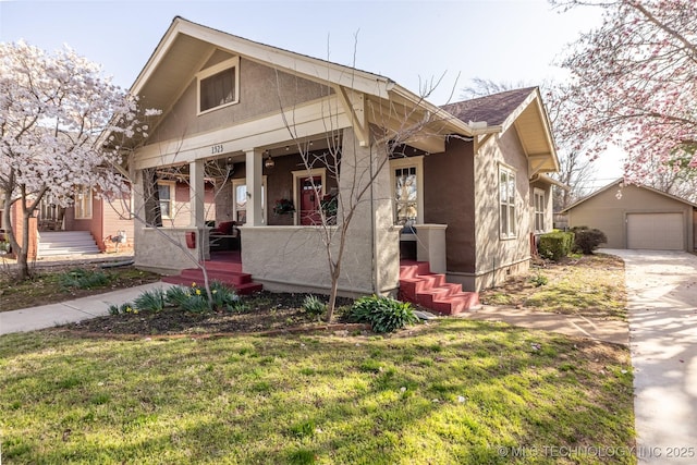 bungalow-style house with an outbuilding, driveway, a detached garage, a porch, and a shingled roof