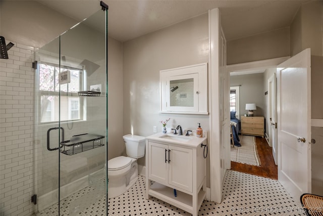 full bathroom featuring vanity, a shower stall, toilet, and ensuite bath