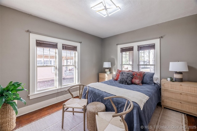 bedroom with baseboards and wood finished floors