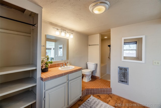 bathroom with visible vents, toilet, backsplash, walk in shower, and vanity