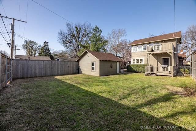 view of yard featuring an outbuilding, a deck, a balcony, and a fenced backyard