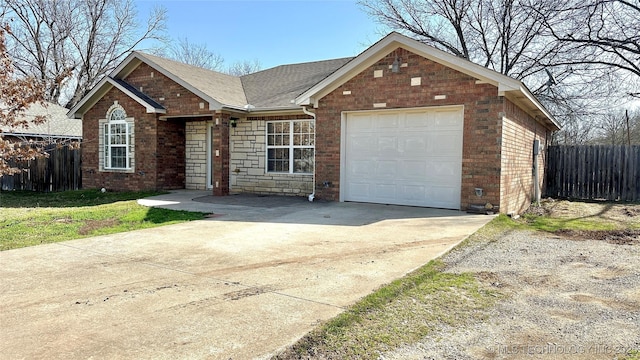 ranch-style home with brick siding, fence, concrete driveway, roof with shingles, and an attached garage