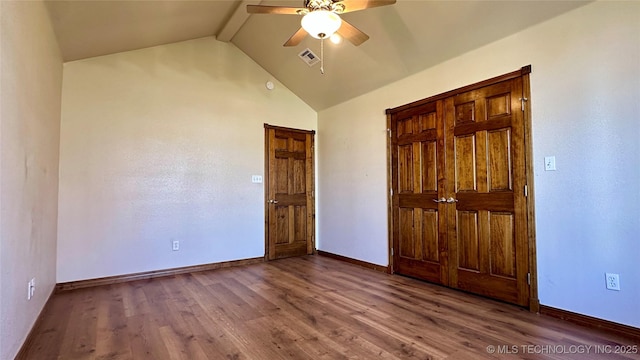 unfurnished bedroom featuring lofted ceiling with beams, wood finished floors, baseboards, and visible vents