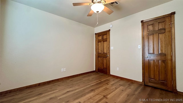 unfurnished bedroom featuring visible vents, a ceiling fan, baseboards, and wood finished floors