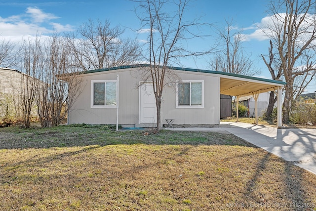 view of front of property with an attached carport, concrete driveway, and a front lawn