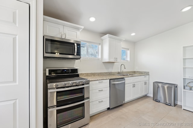 kitchen with recessed lighting, white cabinets, appliances with stainless steel finishes, and a sink