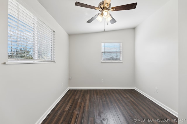 spare room featuring a ceiling fan, baseboards, and dark wood-style flooring