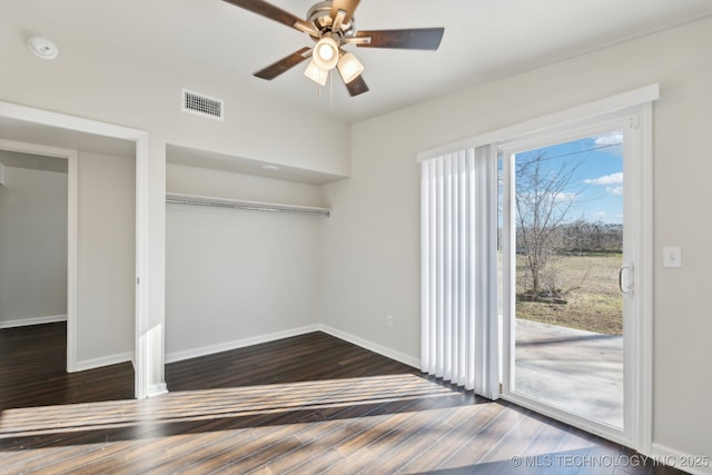 unfurnished bedroom featuring access to exterior, visible vents, dark wood-type flooring, and baseboards