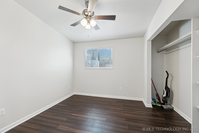 unfurnished bedroom featuring baseboards, dark wood-style floors, and a ceiling fan