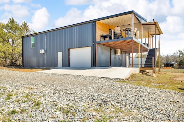 exterior space featuring stairs, a garage, and driveway