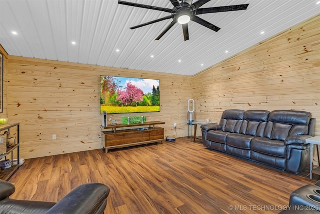 living area with a ceiling fan, vaulted ceiling, wood finished floors, and wood walls