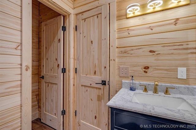 bathroom with vanity and wood walls