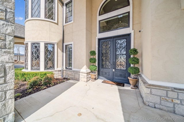 property entrance with stone siding and stucco siding