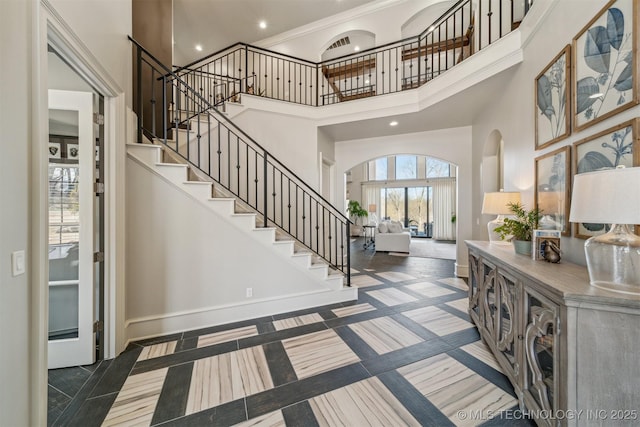 entryway with stairway, recessed lighting, a high ceiling, and baseboards