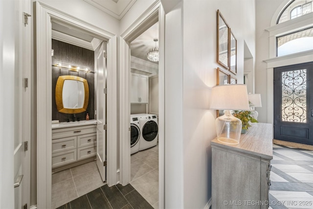 interior space featuring crown molding, a notable chandelier, and washing machine and clothes dryer