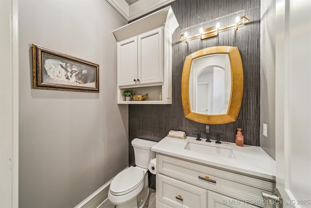 bathroom with vanity, toilet, and baseboards