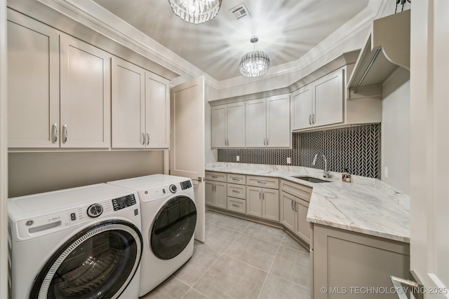 laundry room with light tile patterned floors, visible vents, cabinet space, a sink, and washer and clothes dryer