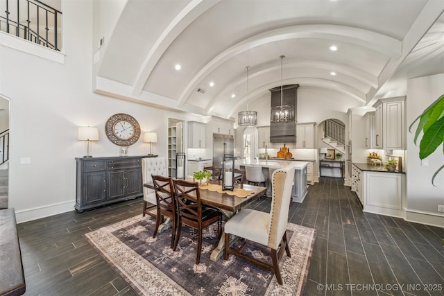 dining area with recessed lighting, stairs, baseboards, and vaulted ceiling