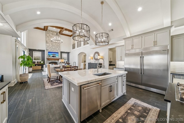 kitchen with gray cabinetry, a sink, dark wood finished floors, recessed lighting, and stainless steel appliances