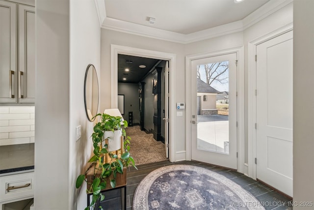 foyer entrance with dark wood-type flooring and ornamental molding