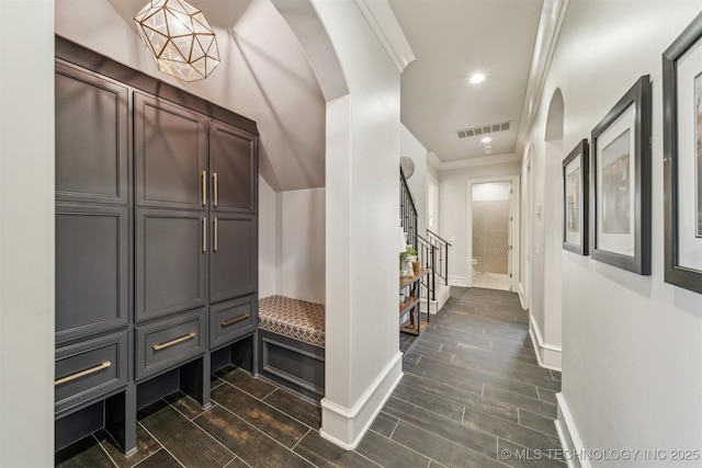 hall featuring baseboards, visible vents, wood tiled floor, arched walkways, and crown molding