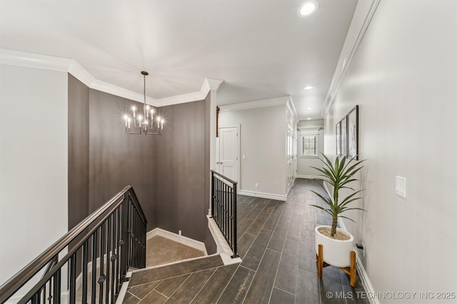 corridor featuring an upstairs landing, baseboards, wood finish floors, and ornamental molding