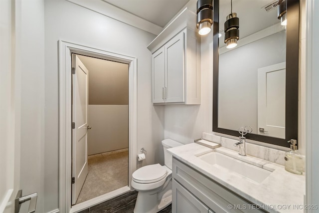 bathroom with vanity, toilet, and visible vents