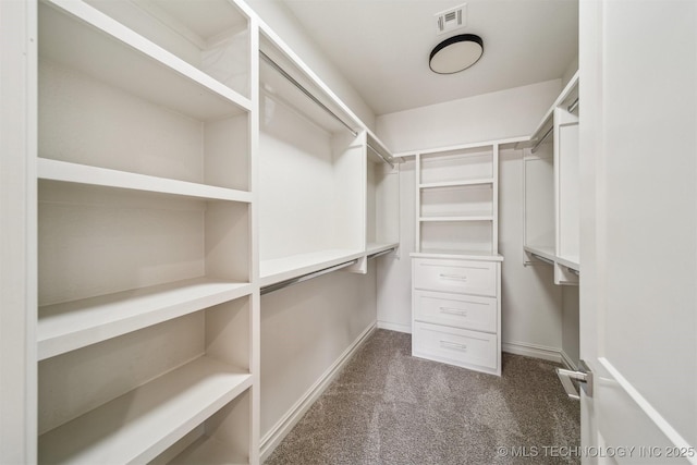 walk in closet featuring visible vents and dark carpet