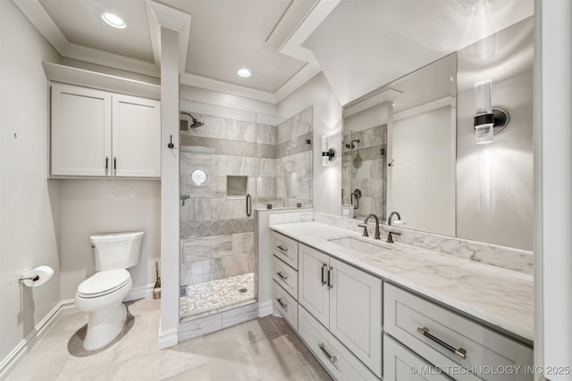 bathroom with a stall shower, toilet, vanity, and baseboards