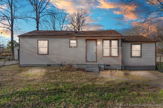 view of front of home featuring a lawn, fence, and crawl space