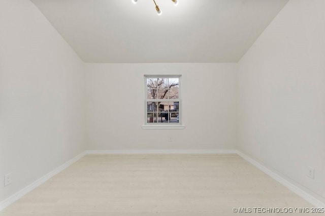 empty room featuring baseboards and light wood finished floors