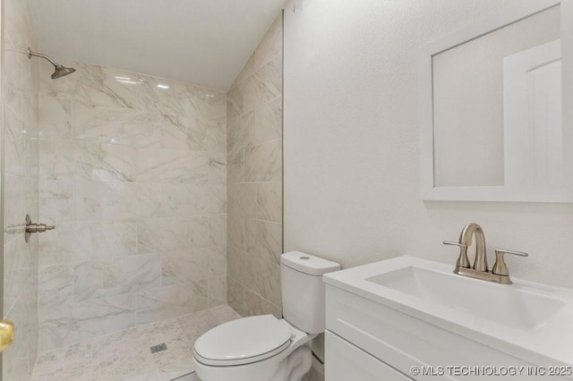 full bathroom with vanity, toilet, and tiled shower