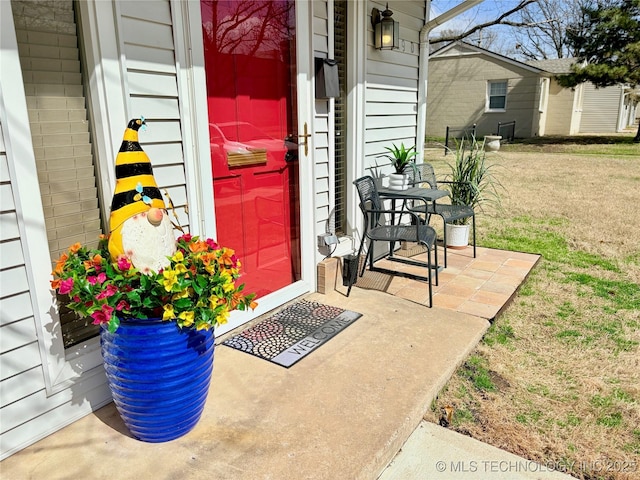 view of exterior entry featuring a lawn