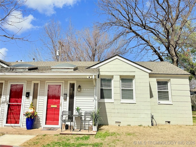 view of front of property with solar panels, roof with shingles, and crawl space