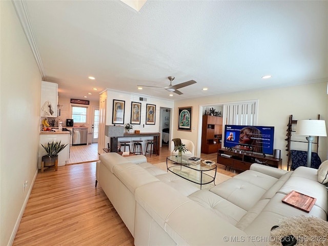 living room featuring a ceiling fan, crown molding, recessed lighting, and light wood-type flooring