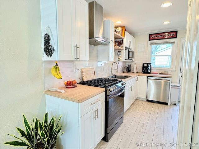 kitchen with decorative backsplash, extractor fan, light countertops, light wood-style floors, and appliances with stainless steel finishes